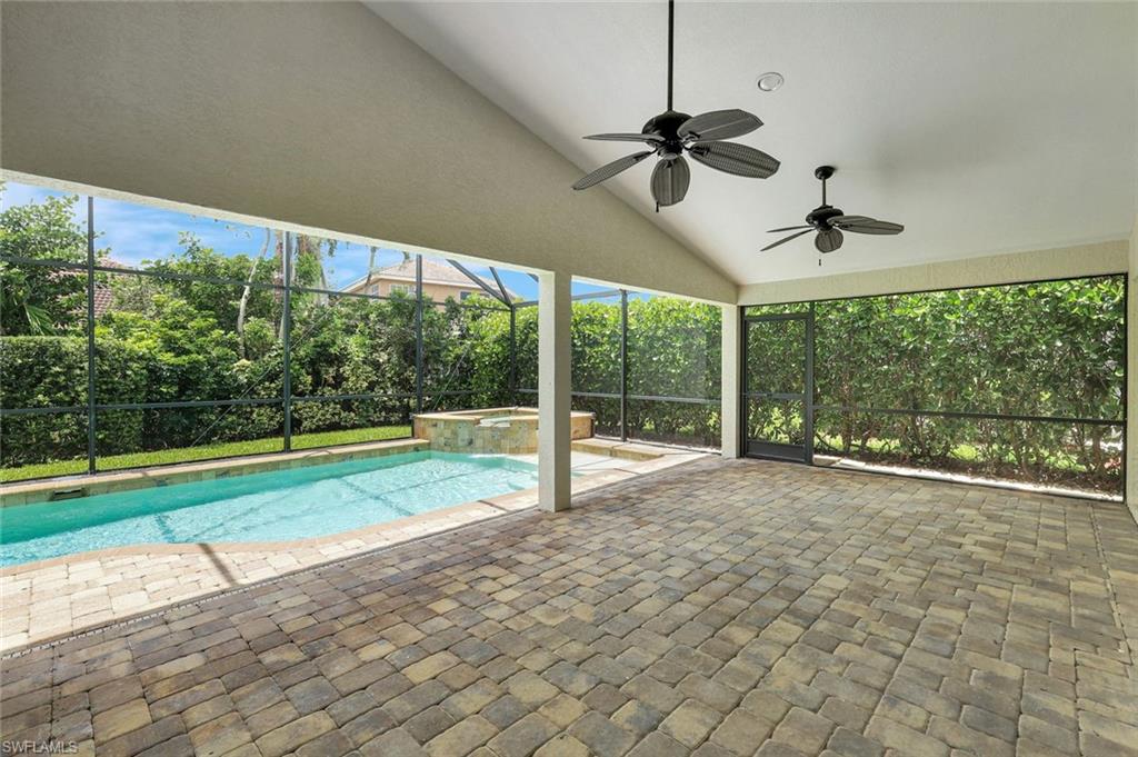 Screened lanai featuring a swimming pool, integrated spa, and paver flooring
