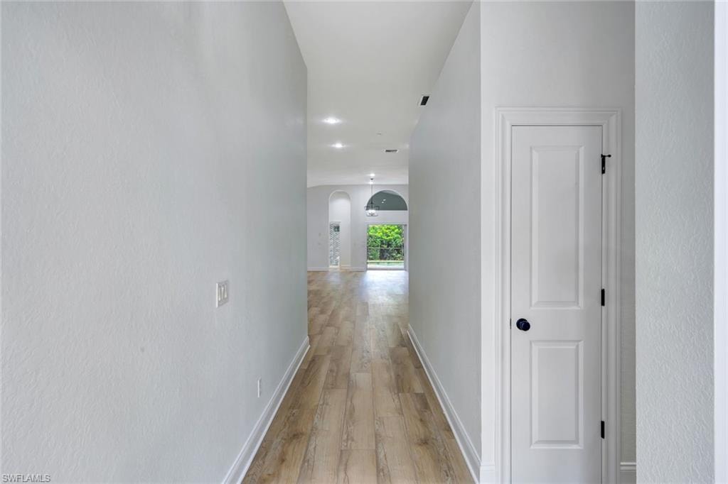 Hallway with wood-finish flooring and recessed lighting