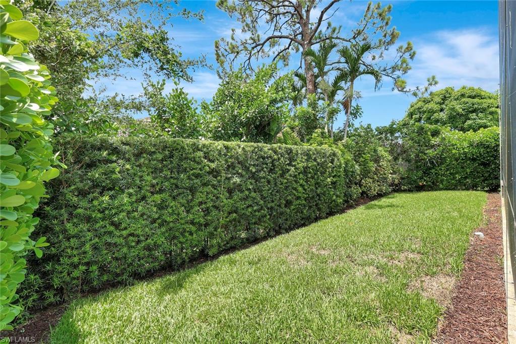 Manicured lawn area with a well-maintained hedge and mature trees