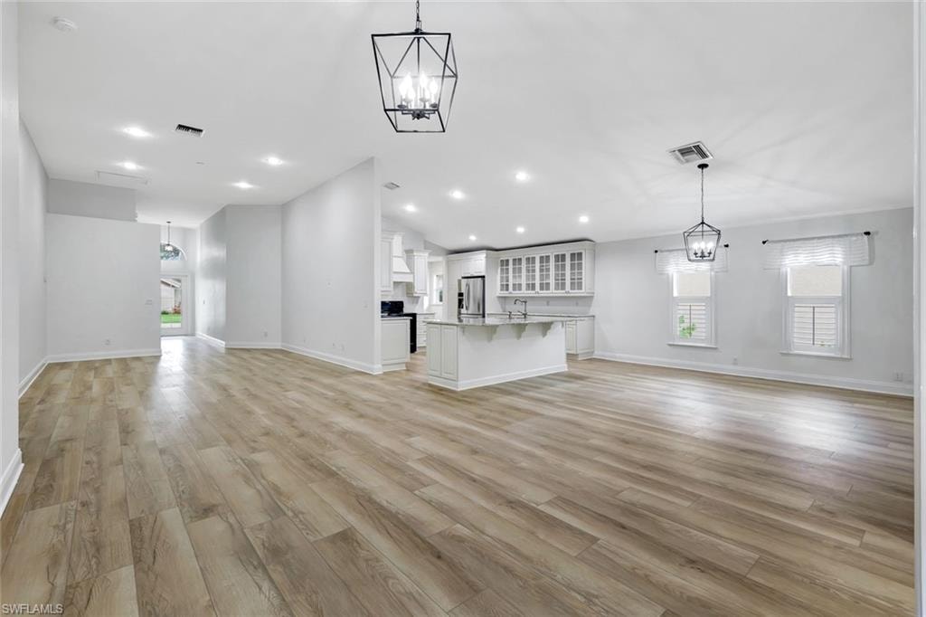 Open-concept living space featuring wood-finish flooring, recessed lighting, and modern pendant light fixtures