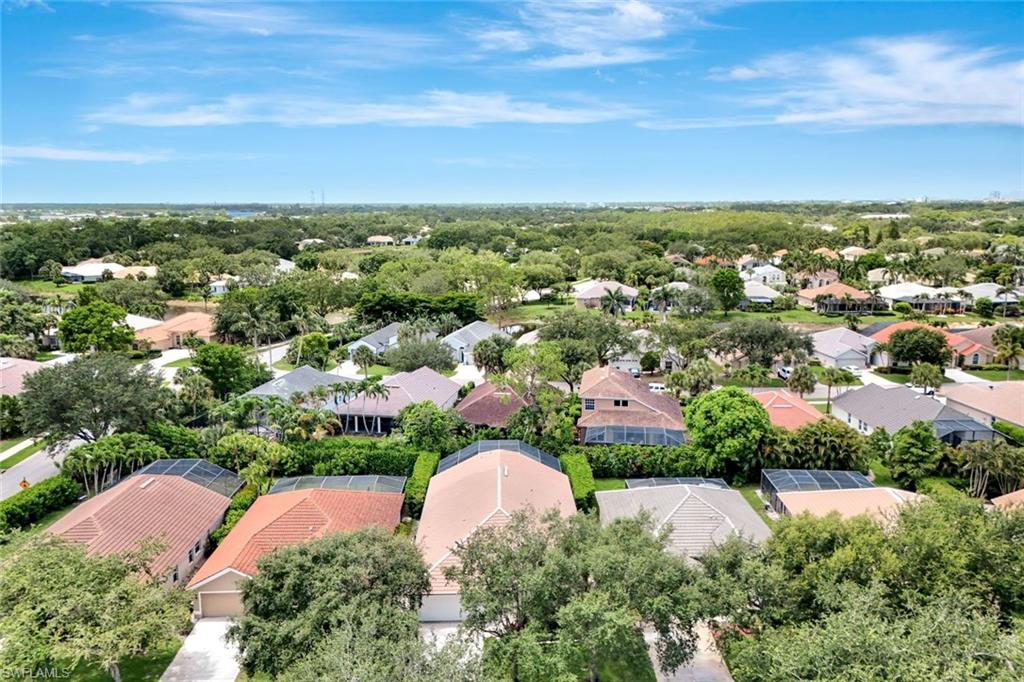 Aerial perspective showcasing residential properties with mature landscaping and clear skies