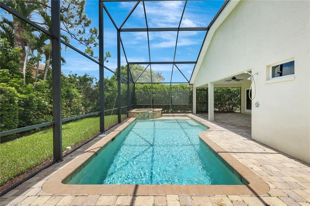 Screened-in swimming pool and spa with paver deck