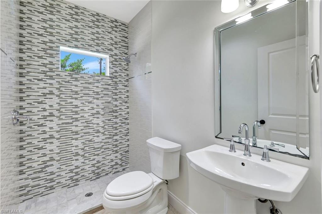 Pedestal sink with chrome fixtures and an ornate framed mirror