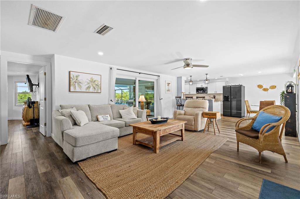 Wood-finish flooring throughout, recessed ceiling lighting, ceiling fan, and sliding glass doors