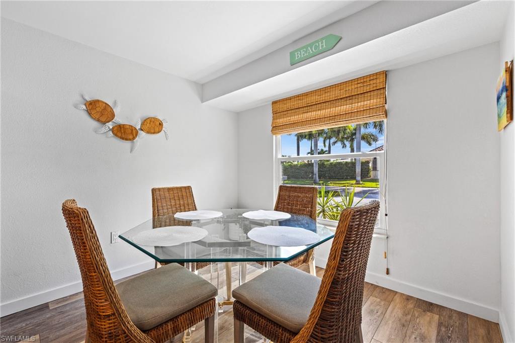 Crisp white walls, wood-finish flooring, and a window with a woven shade