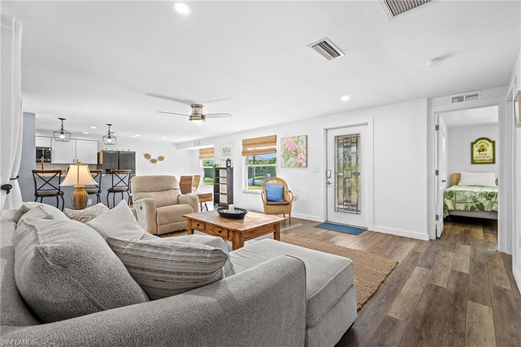 Spacious living area with wood-finish flooring, recessed lighting, and a ceiling fan