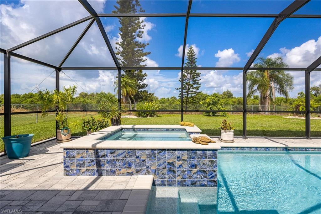 Screened enclosure with a pool, integrated spa, and tile-accented spa surround