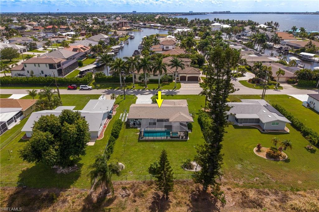 Property featuring a private swimming pool, screened enclosure, and an expansive manicured lawn