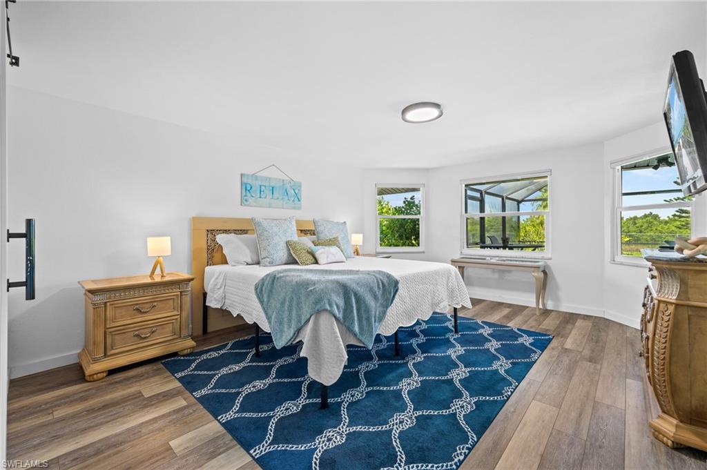 Wood-finish flooring, multiple windows, and a recessed ceiling light fixture