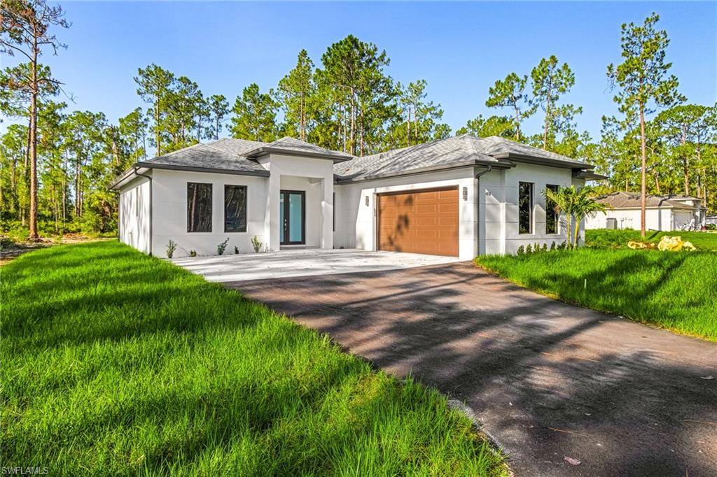 Contemporary stucco exterior, dark frame windows, wood-finish garage door, and a light-colored entry door