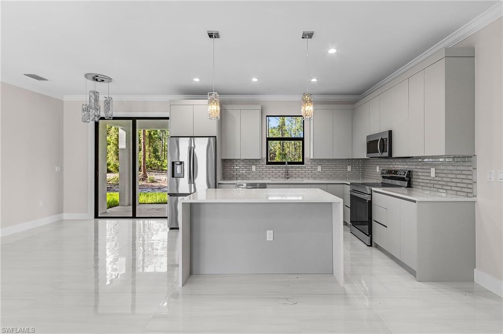 Gourmet kitchen with an island, stainless steel appliances, modern cabinetry, subway tile backsplash, and polished tile flooring