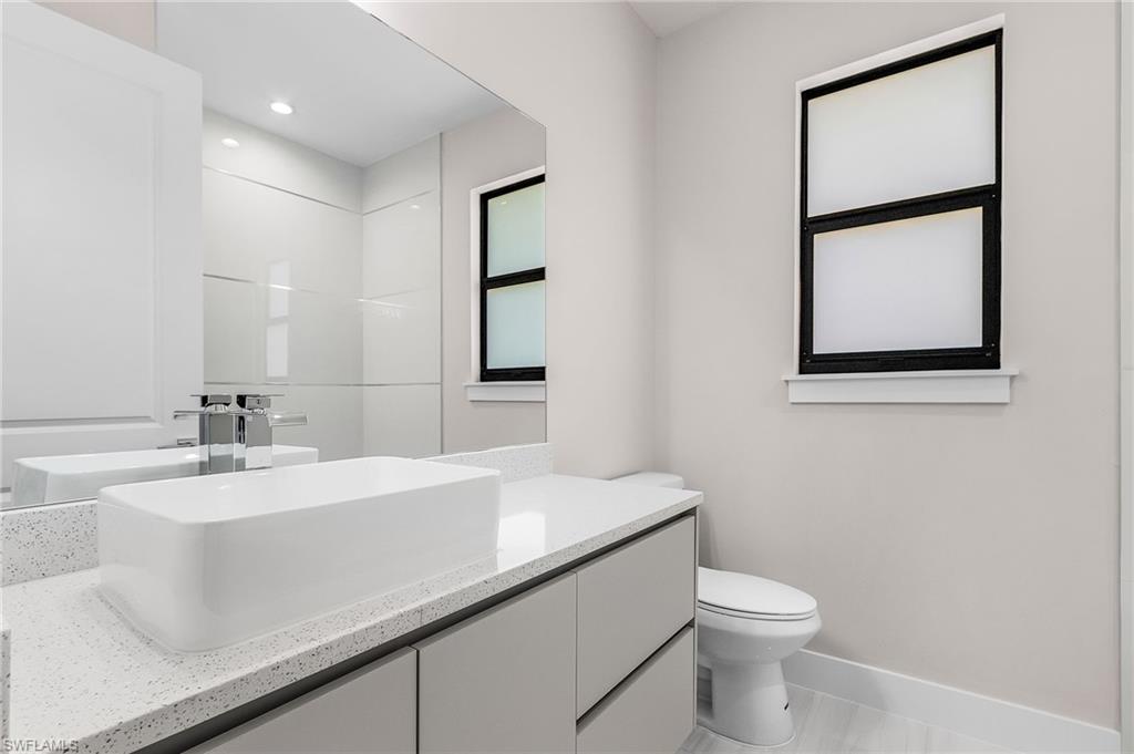 Wall-mounted vanity with a rectangular vessel sink, chrome faucet, and integrated mirror