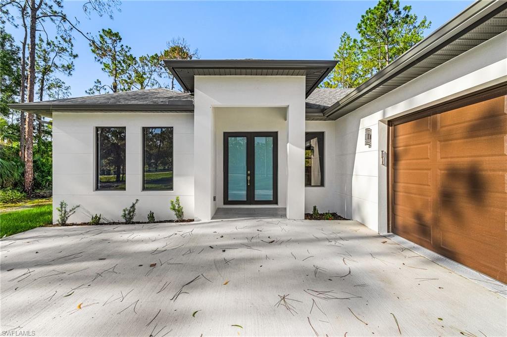 Modern exterior with a light-toned stucco finish and dark trim