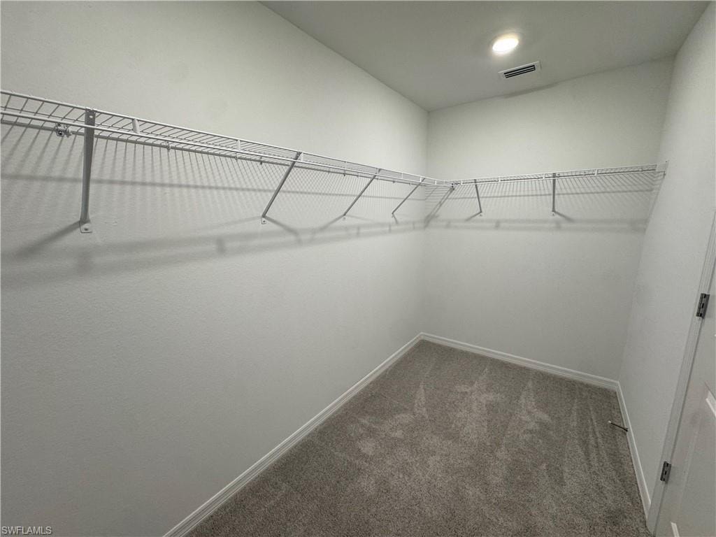 Walk-in closet with wire shelving, recessed lighting, and grey carpet flooring