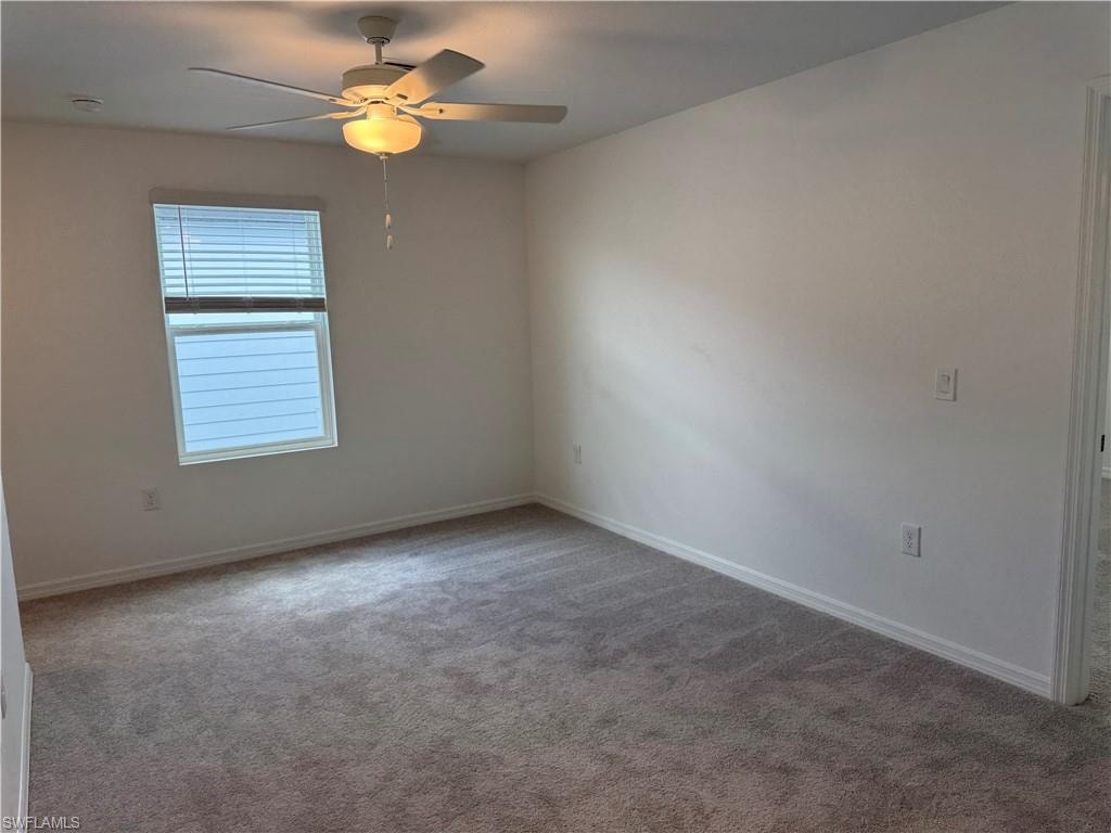 Recessed window with blinds, ceiling fan with integrated lighting, and neutral carpeting