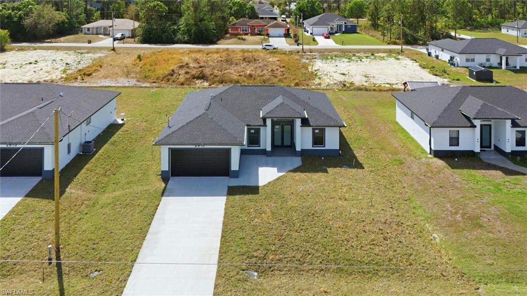 Contemporary single-story residence featuring a dark shingle roof, white exterior siding, and an attached two-car garage