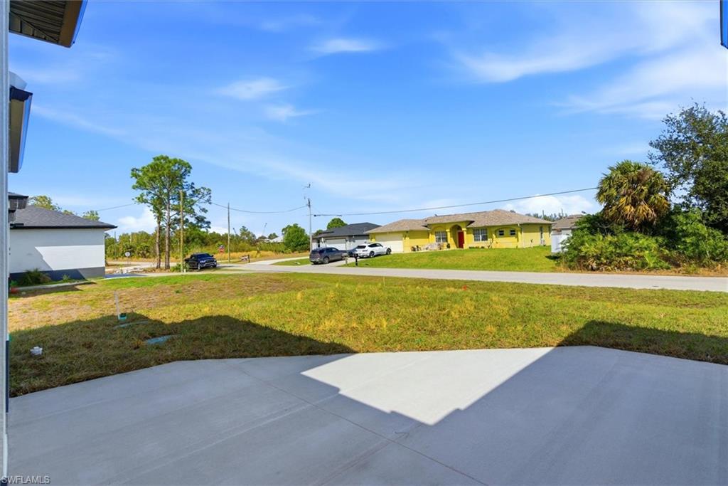 Large concrete patio opening to a spacious grassy area