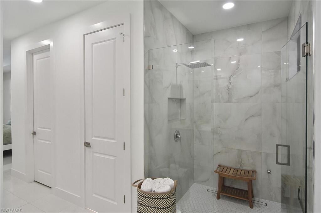 Ensuite bathroom with a marble finish shower, tile patterned flooring, and recessed lighting