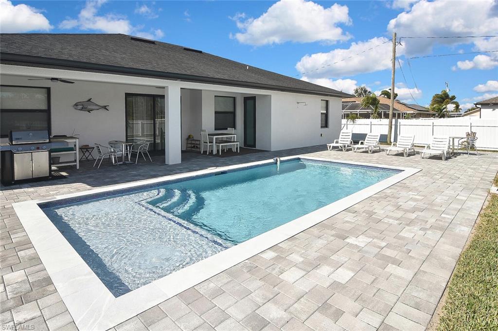 View of pool featuring a patio, a grill, and outdoor dining area