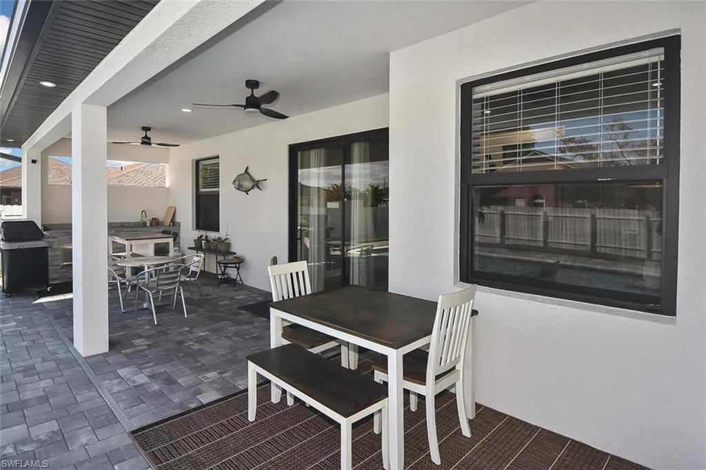 View of patio with outdoor dining space, a ceiling fan, and area for grilling