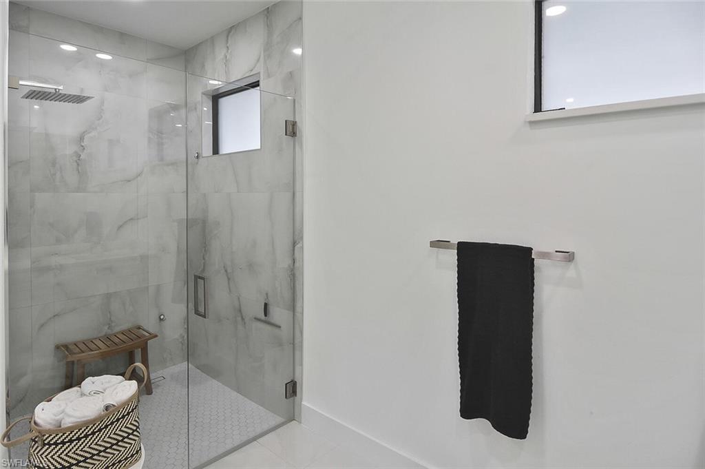 Full bathroom featuring a marble finish shower and recessed lighting