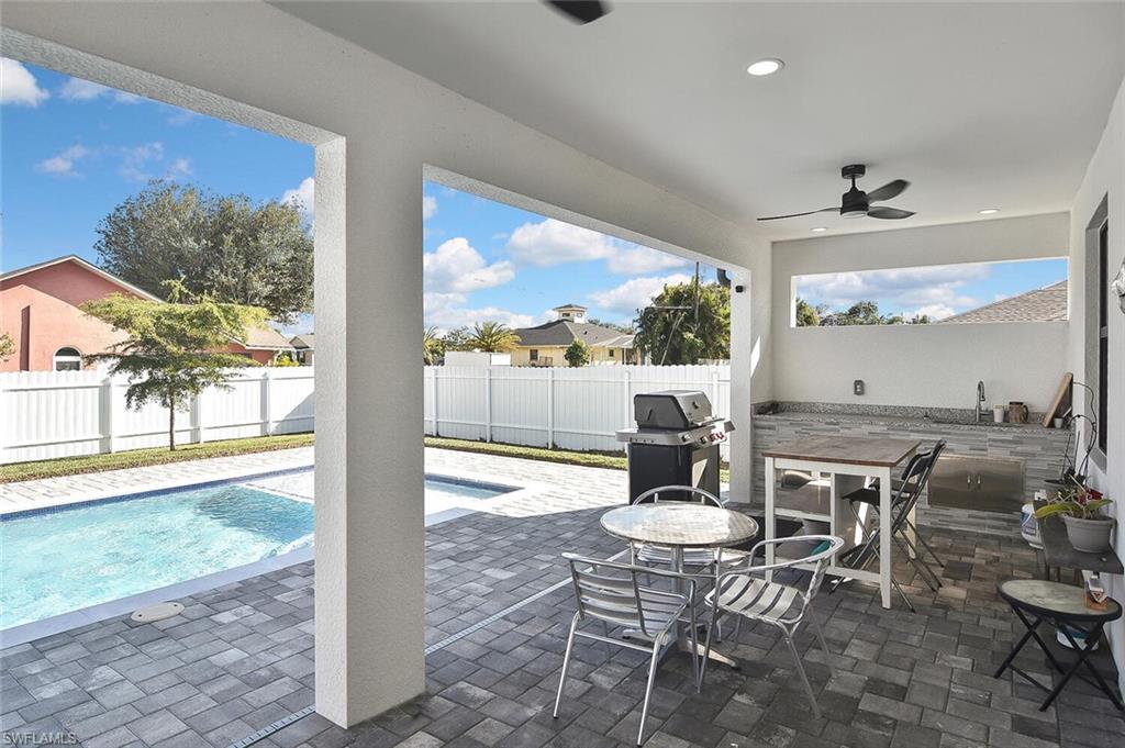 Fenced backyard with a patio area, grilling area, a ceiling fan, and outdoor dining area