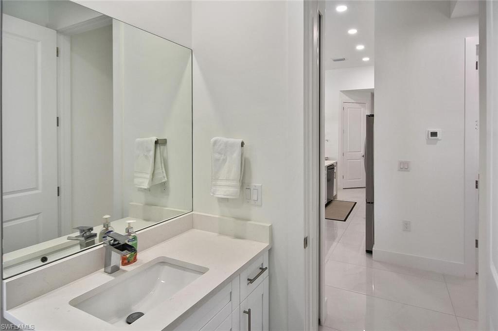 Bathroom with vanity, light tile patterned floors, and recessed lighting