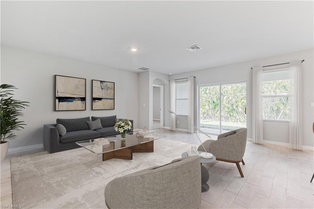 This image is virtually staged. Living area featuring arched walkways and recessed lighting