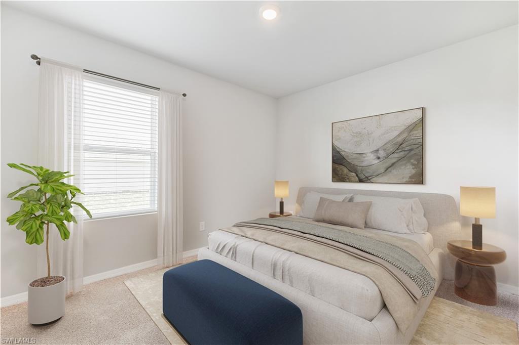 This image is virtually staged. Bedroom featuring light carpet and baseboards