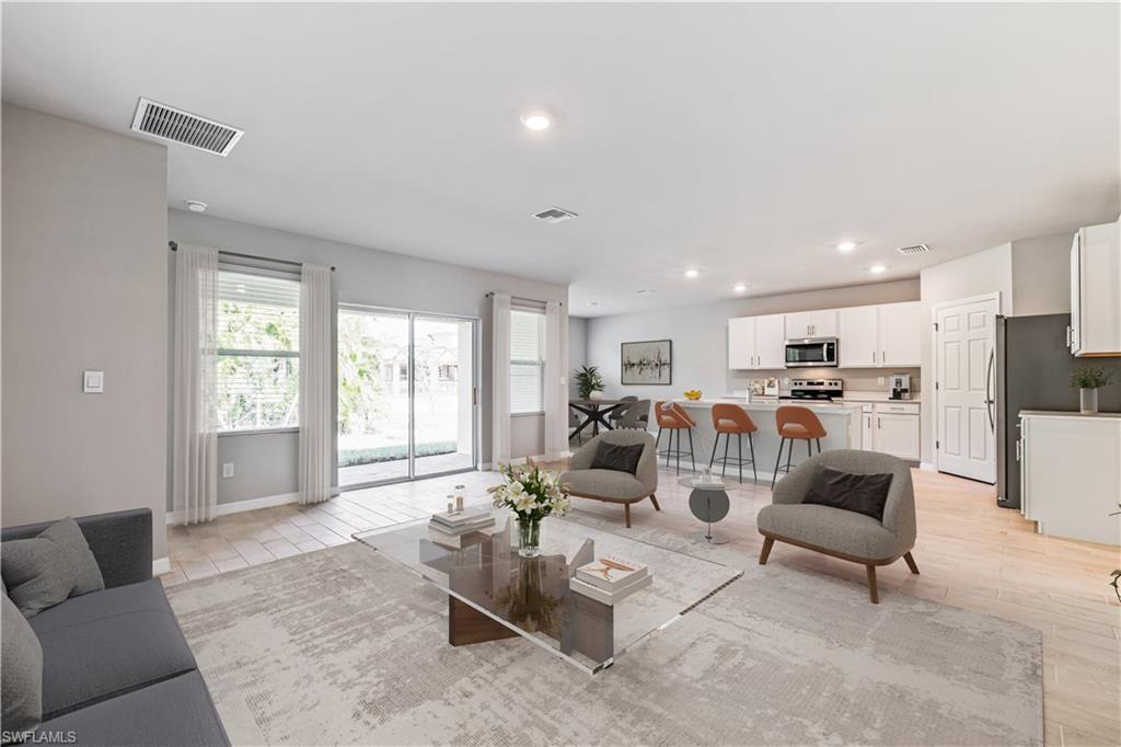 This image is virtually staged. Living area with recessed lighting and baseboards