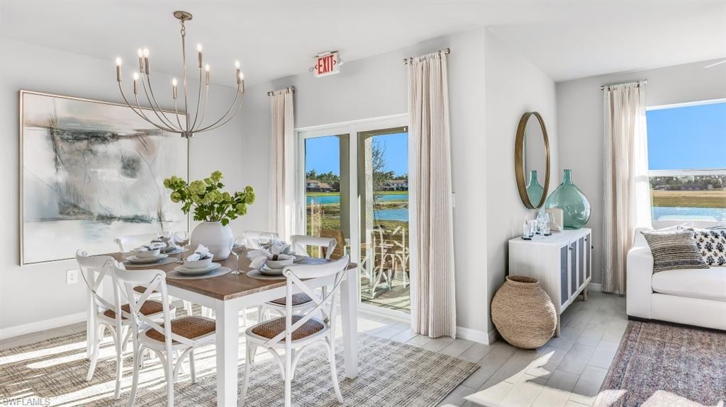 Model home. Dining space featuring light wood-type flooring, suspended lighting, and a water view