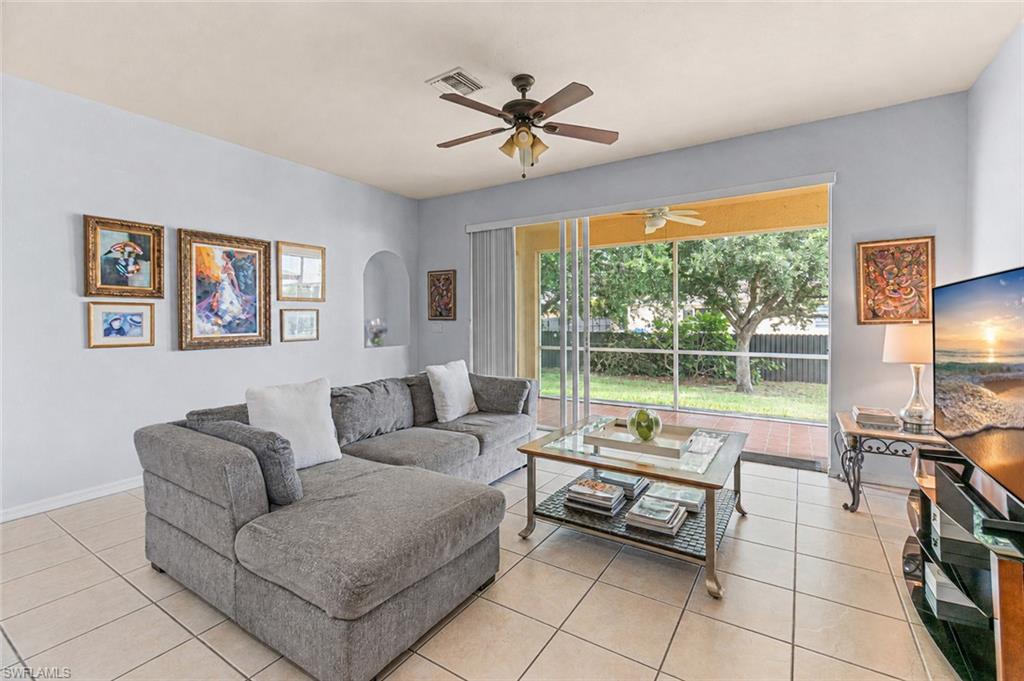Screened-in patio with outdoor ceiling fan, tile flooring, and direct access to a landscaped backyard