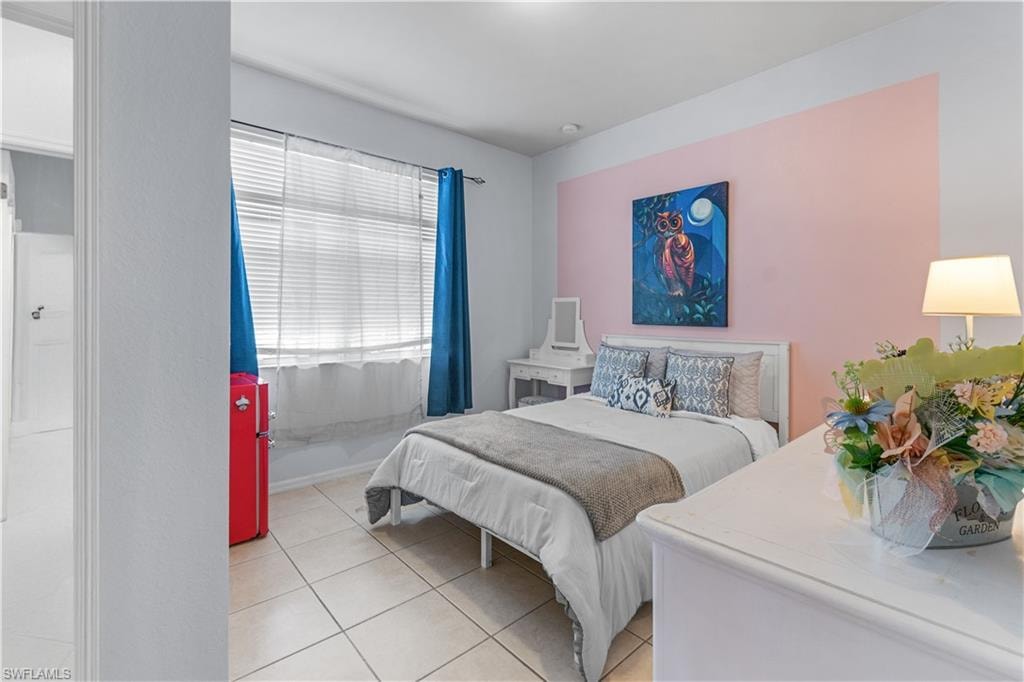 Room with tile flooring, a window with horizontal blinds, and a built-in closet with a white door