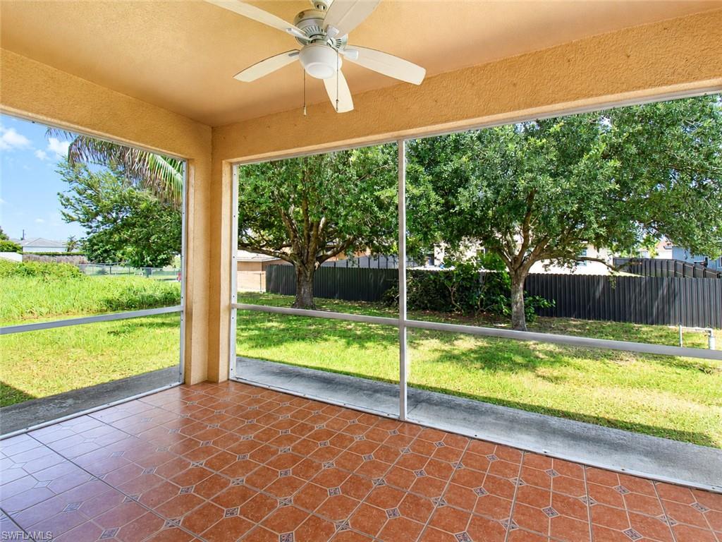 Screened patio featuring a ceiling fan, patterned tile flooring, and direct access to the outdoor area
