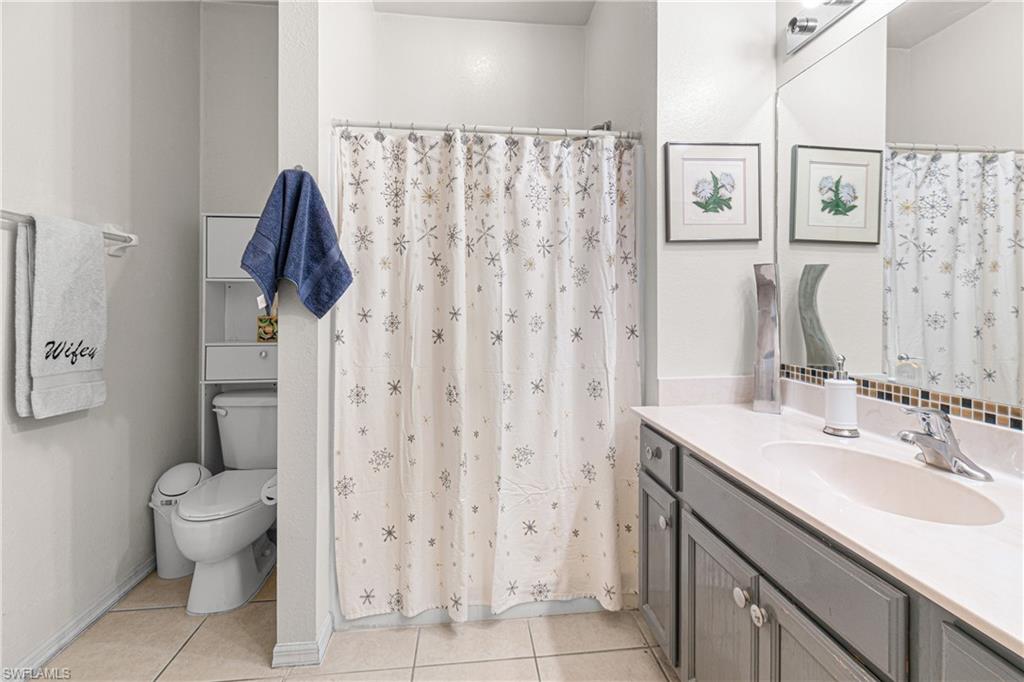 Single vanity with a light-toned countertop, under-mount sink, and chrome faucet